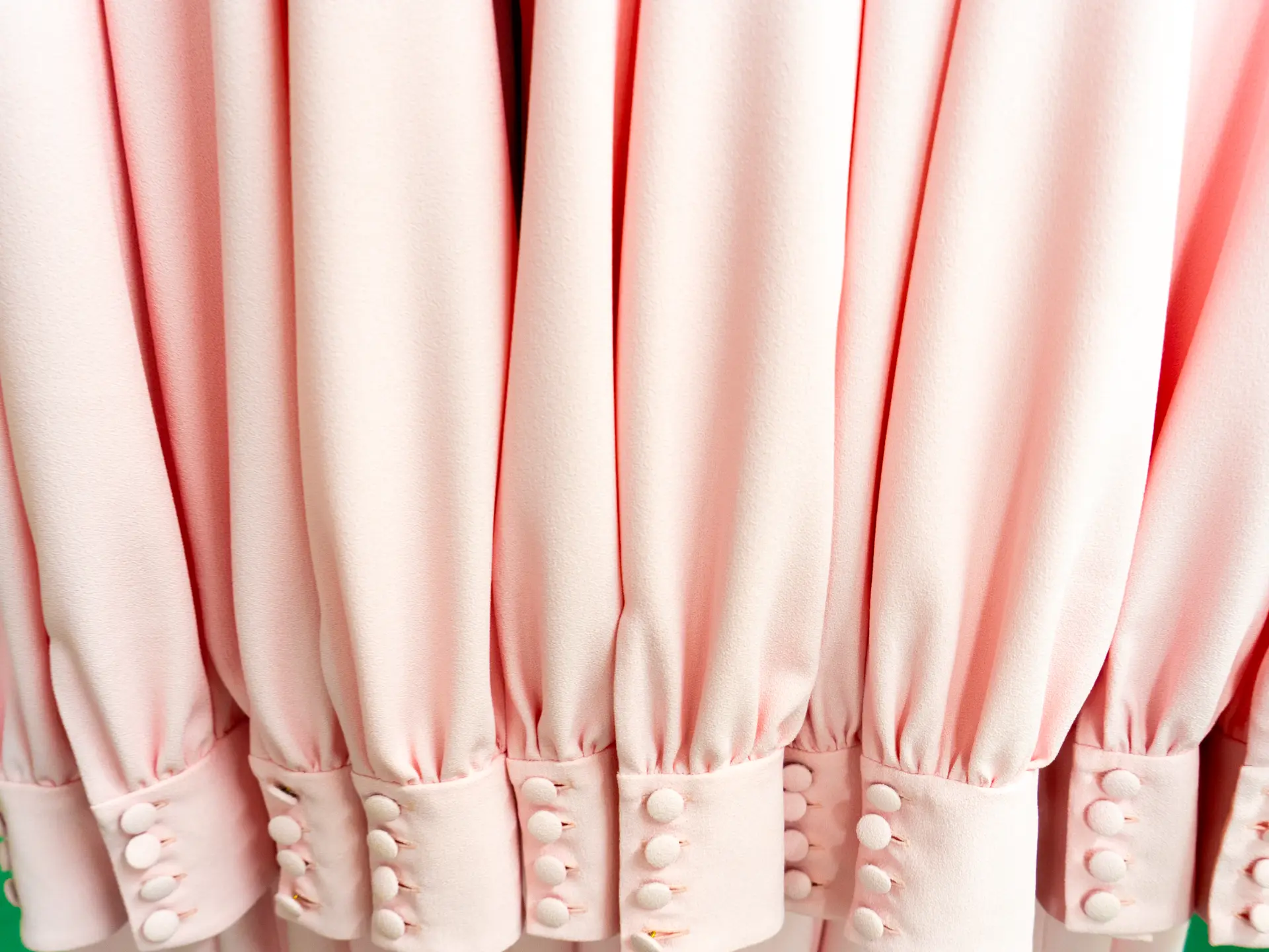 Close-up of pale pink gathered sleeves with buttoned cuffs at CMT Studio London