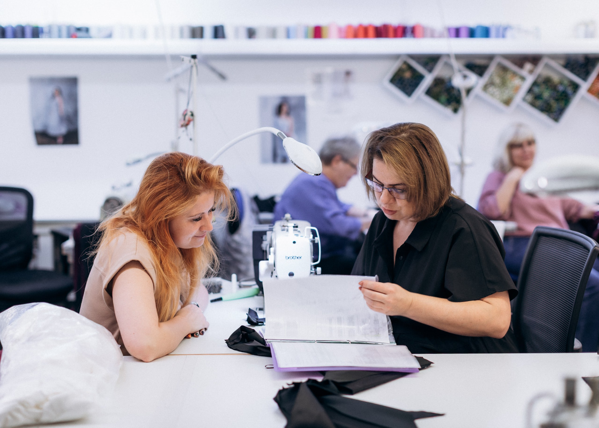 Machinist and production manager reading a tech pack together at the sewing machine
