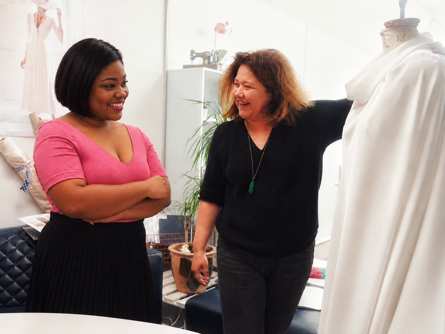 Two women discussing a white draped garment on a dress form at CMT Studio London