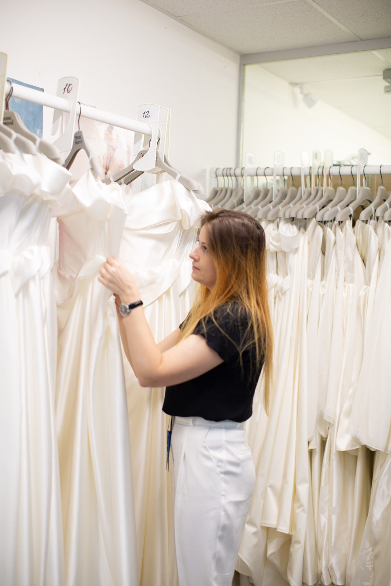 Bridal gowns hanging on rails in the studio, ready for production