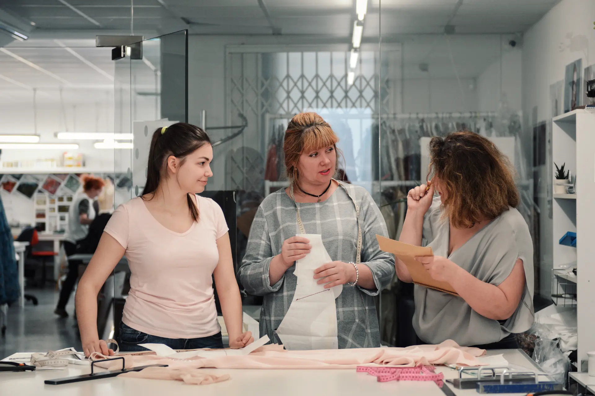 Pattern cutters reviewing a pattern piece and sample notes at the cutting table