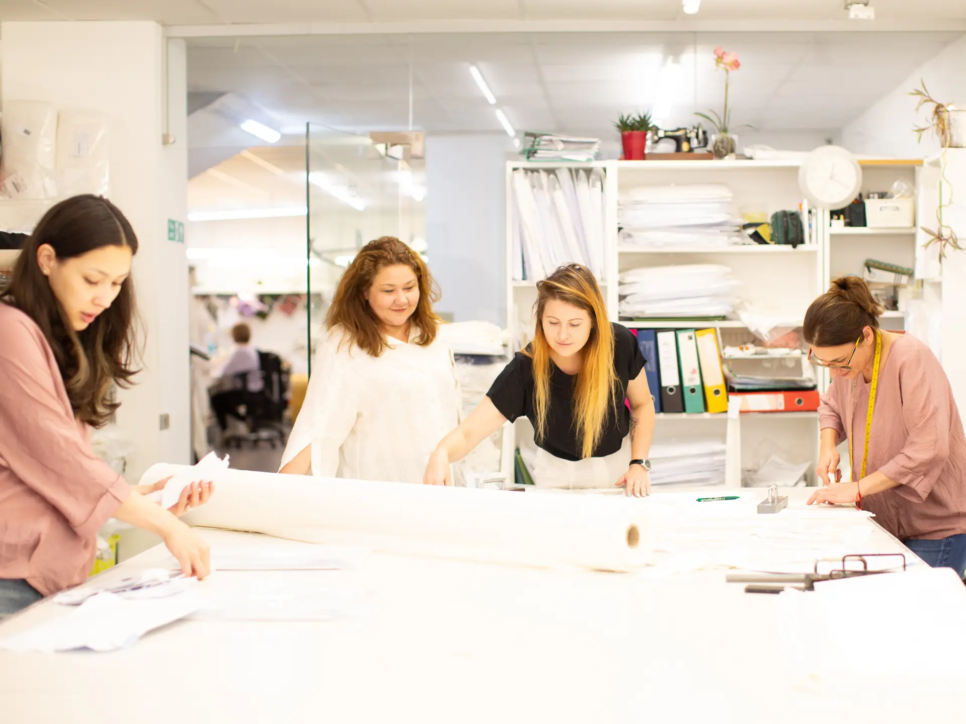 CMT Studio team reviewing fabric and patterns around the cutting table
