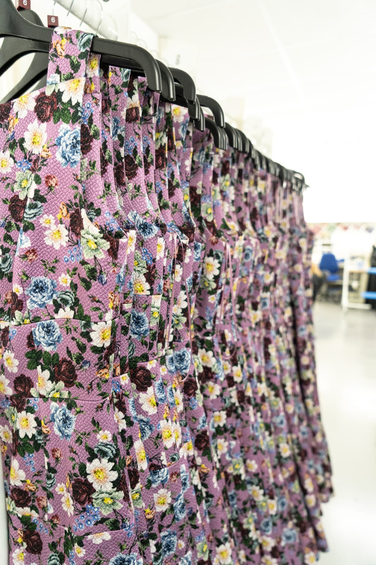 A production run of floral printed garments hanging on the rail in the studio