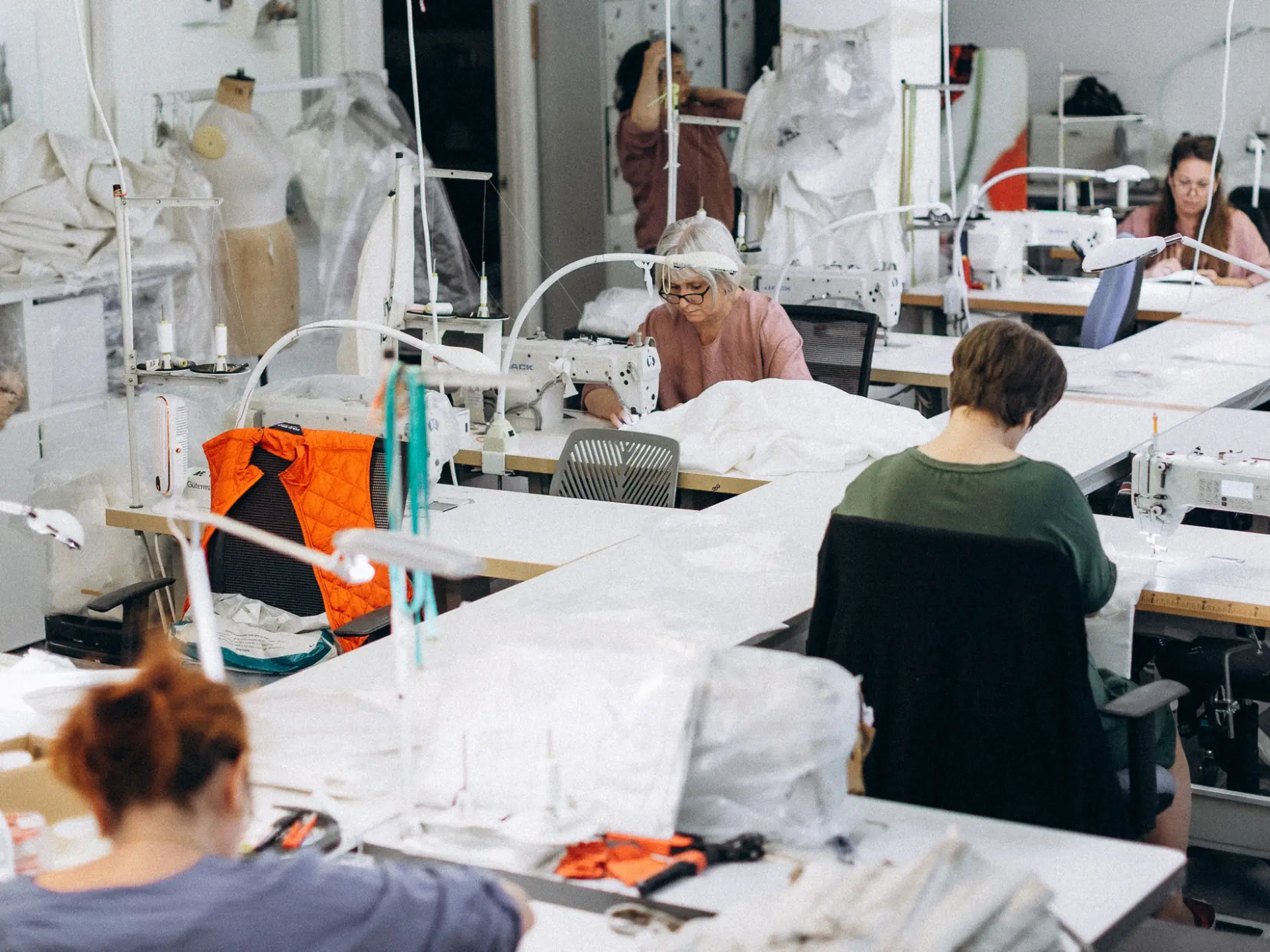 Machinists at work on white fabric across the CMT Studio production floor